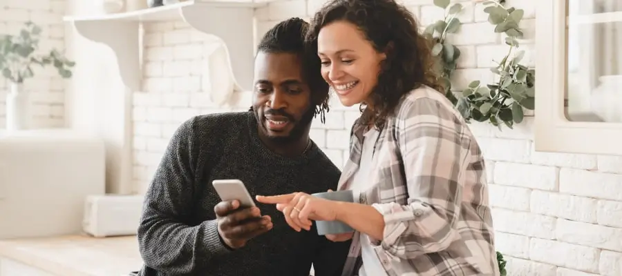 man and woman looking at phone